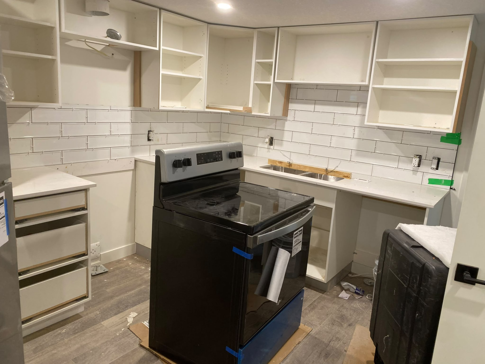Kitchen cabinetry and white tile backsplash work in progress